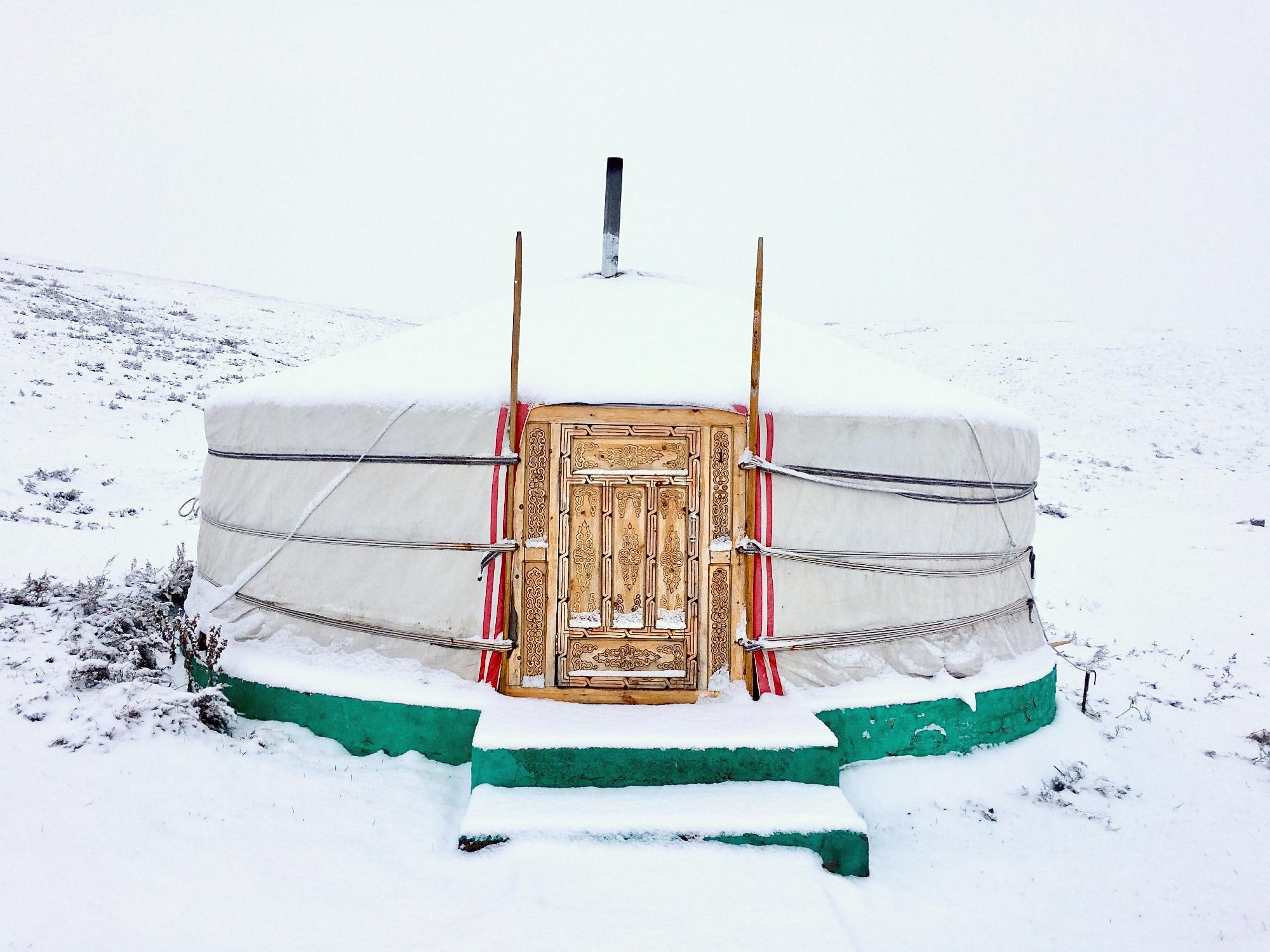 A yurt surrounded by snow.