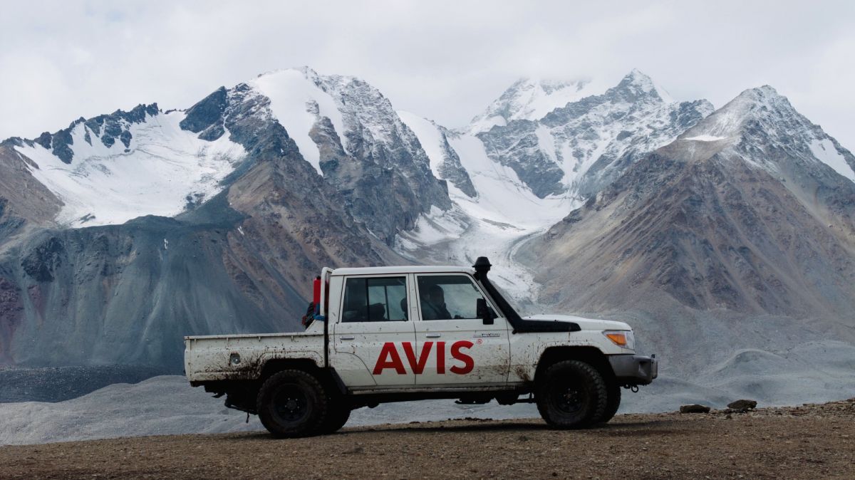 An Avis offroad vehicle awaits adventure against Mongolia’s rugged mountains in the cold winter.